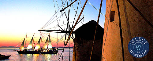 Sailing ships at sunset and windmills